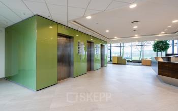 Ruime, moderne entree van het kantoorpand Hoeksteen 54-72 in Hoofddorp met liften en ontvangstbalie.