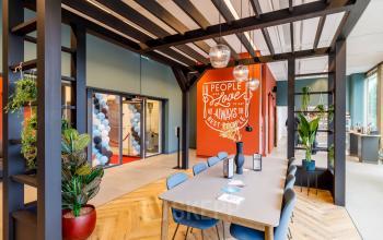 Moderne ontvangstruimte van kantoor op Spicalaan 1-59 in Hoofddorp, met grote tafel, groene planten en decoraties. Ideaal voor kantoorruimte huren.