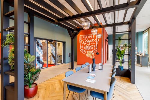Moderne ontvangstruimte van kantoor op Spicalaan 1-59 in Hoofddorp, met grote tafel, groene planten en decoraties. Ideaal voor kantoorruimte huren.