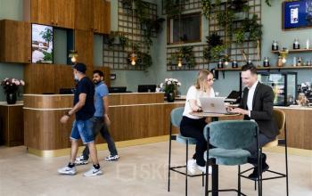 Entree van het kantoorpand op Mercuriusplein 1 in Hoofddorp met mensen aan tafels en bij een balie, bezig met zakelijke gesprekken en activiteiten. Ideale ruimte om kantoorruimte te huren.