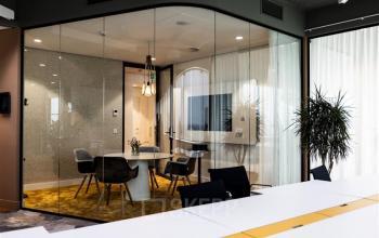 Modern kantoor met glazen wanden, vergadertafel en stoelen op Mercuriusplein 1, Hoofddorp. Ideaal voor kantoorruimte huren.