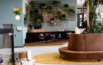 Kantoorruimte huren op Mercuriusplein 1 in Hoofddorp met een moderne lounge, stijlvolle zitplaatsen en decoratieve planten. Ideaal voor informele meetings of pauzes.