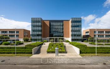 Moderne kantoorpand gelegen aan Siriusdreef 60 in Hoofddorp met opvallende glazen gevel en omliggende groenvoorzieningen. Ideale plek voor kantoorruimte huren met ruime parkeerfaciliteiten.