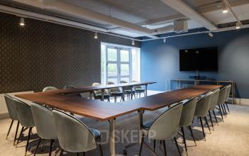 Stijlvol ingerichte vergaderruimte binnen een kantoorpand op Siriusdreef 60, Hoofddorp, met een lange tafel en comfortabele stoelen.