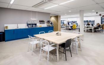 Licht en modern kantoorpand met open werkruimte en vergadertafel op Siriusdreef 16, ideaal voor kantoorruimte huren in Hoofddorp.