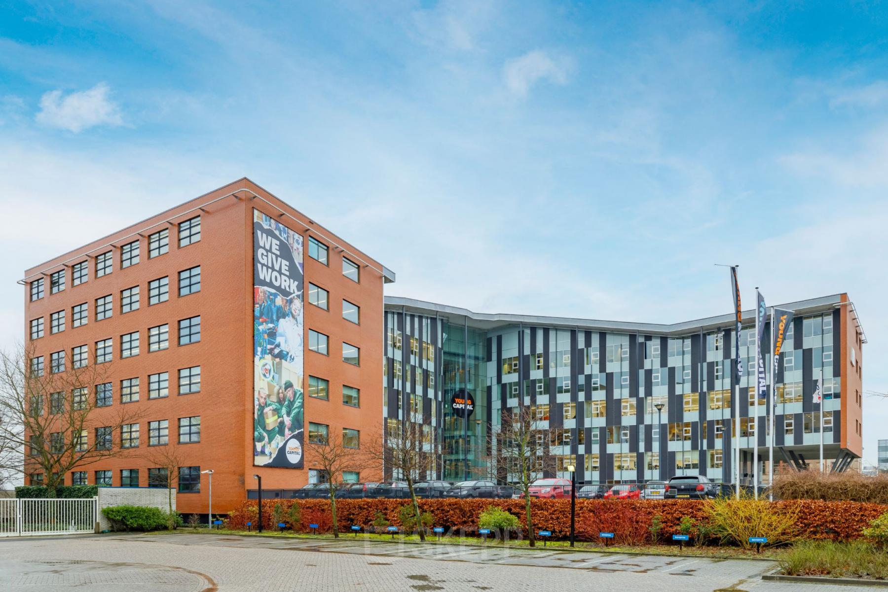 Buitenzijde van het kantoorpand op Siriusdreef 16 in Hoofddorp, met moderne architectuur en ruime parkeerplaats. Geschikt voor kantoorruimte huren in een levendige omgeving.