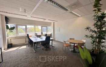 Kantoorruimte huren op Planetenweg 5 in Hoofddorp met ruime werkplekken, grote ramen en veel natuurlijk licht. Verschillende moderne bureaus en stoelen staan opgesteld in een lichte en frisse omgeving.