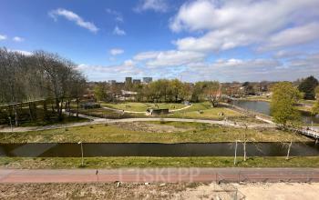 Uitzicht op groen park met wandelpaden en water nabij Planetenweg 5 in Hoofddorp, ideaal gelegen voor kantoorruimte huren in een rustige omgeving.