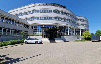 Het kantoorpand op Planetenweg 5 in Hoofddorp toont een modern gebouw met een stijlvolle ingang, ideaal voor bedrijven die kantoorruimte willen huren.