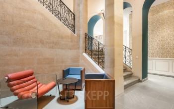 Stijlvolle kantoorruimte huren op Siriusdreef 17, Hoofddorp met designstoelen, houten tafels en een prachtig trapontwerp.