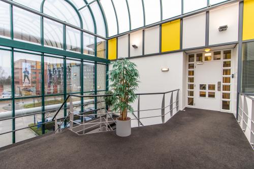 Lichtovergoten entreehal in kantoorpand op Siriusdreef 17, Hoofddorp, met plant en moderne architectuur.
