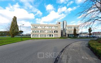 Een modern kantoorpand aan de Meidoornkade 19 in Houten met heldere glazen gevel en ruime parkeerfaciliteiten. Ideale locatie om kantoorruimte te huren.