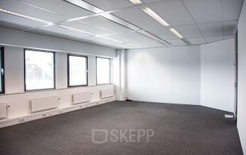 Leeg kantoorpand op Meidoornkade 22 in Houten met grijze gestoffeerde vloer en enkele grote ramen, ideaal voor huren.