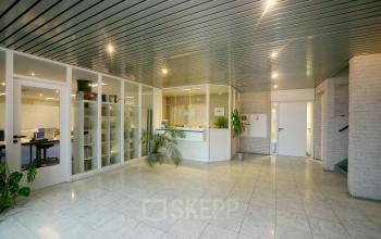 Ruime, lichte kantoorruimte huren op Sandtlaan 36 in Katwijk, met glazen wanden, tegelvloer en ingebouwd boekenrek. Ideaal kantoorpand voor zakelijke huur.