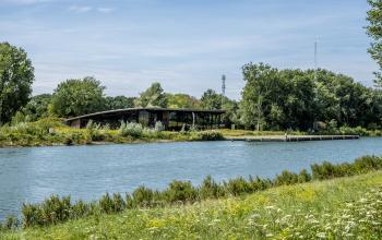 Exterieurfoto van kantoorpand gelegen aan de Oudhuizerstraat 31, Klarenbeek met uitzicht op een naastgelegen waterpartij en omringende groene natuur.