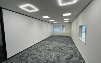 Kantoorpand op Industriepark 5B in Leek met moderne verlichting en grijze vloerbedekking biedt ruimte voor jouw bedrijfsactiviteiten. De lichte omgeving is ideaal voor kantoorruimte huren.