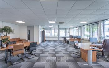 Interieur van een ruim kantoor met meerdere bureaus en stoelen, grote ramen voor natuurlijk licht, gelegen op Ouddeelstraat 7a in Leeuwarden. Geschikt voor bedrijven die kantoorruimte willen huren.