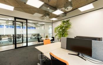 Kantoorruimte huren op Lange Marktstraat 1, Leeuwarden. Moderne werkplekken met grote ramen, natuurlijk licht en groene planten.