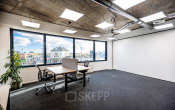 Moderne kantoorruimte in Leeuwarden met grote ramen, lichte muren en bureaus bij Lange Marktstraat 1, ideaal om te huren voor bedrijven die een frisse werkplek zoeken.