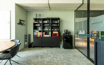 Kantoorruimte huren aan de Lange Marktstraat 1, Leeuwarden met bureau, stoelen, kast en glazen scheidingswand.