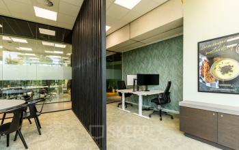 Modern kantoorpand aan de Lange Marktstraat 1, Leeuwarden met glazen wanden, bureaus en stoelen, geschikt voor kantoorruimte huren.