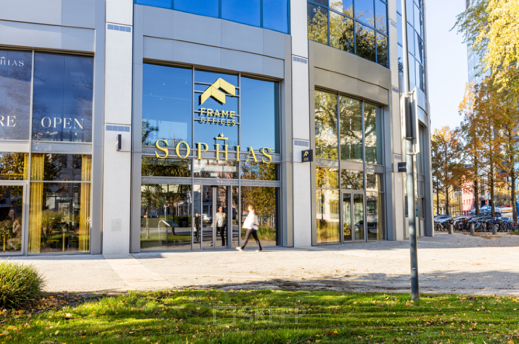 Exterieur van het kantoor op Lange Marktstraat 1 in Leeuwarden, met moderne glazen gevel en passanten.