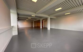 Spacious empty office space at Zwettestraat 15, Leeuwarden, ready for rent. The open interior features neutral tones and ample lighting, perfect for customizing your ideal workspace.