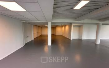 Ruime kantoorpand Zwettestraat 15, Leeuwarden, met industriële uitstraling, klaar voor kantoorruimte huren. Grijze vloer, witte muren en voldoende verlichting.