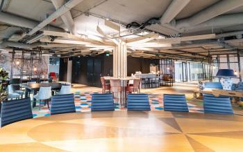 Kantoorpand Schipholweg 103 in Leiden met modern ingericht interieur, kleurrijke vloer en diverse zitgedeeltes. Ruime werkplekken en een comfortabele sfeer maken deze kantoorruimte ideaal voor zakelijke activiteiten.