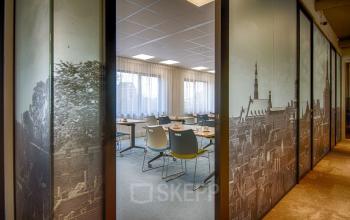 Vergaderruimte in het kantoorpand aan de Schipholweg 103 in Leiden met tafels, stoelen, en grote ramen.