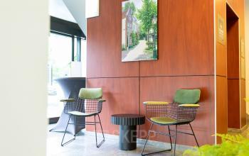 Ontvangstruimte van kantoorpand Pompoenweg 3 - 15, Leiden. Kantoor met twee stoelen, een tafel en een kunstwerk aan de muur.