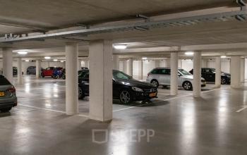 Parkeergarage bij kantoorpand aan Pompoenweg 3 - 15 in Leiden, met diverse geparkeerde auto's en heldere verlichting.