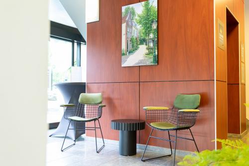Ontvangstruimte van kantoorpand Pompoenweg 3 - 15, Leiden. Kantoor met twee stoelen, een tafel en een kunstwerk aan de muur.