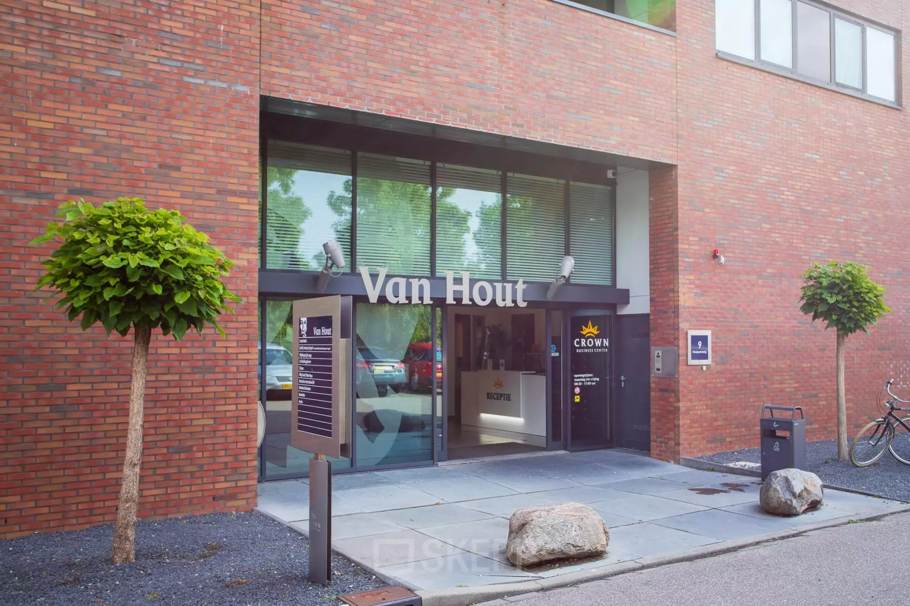 De ingang van een kantoorpand op Pompoenweg 3-15 in Leiden, met het bord 'Van Hout' en glazen deuren die toegang bieden tot de kantoorruimte binnenin.