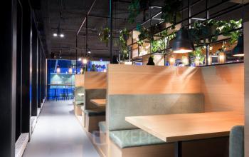 Kantoorruimte huren aan de Bargelaan 200 in Leiden, met houten zithoeken, sfeervolle verlichting en groene accenten.