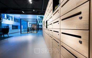 Moderne kantoorruimte huren op Bargelaan 200, Leiden met houten lockers en glazen wanden in een goed verlichte omgeving.