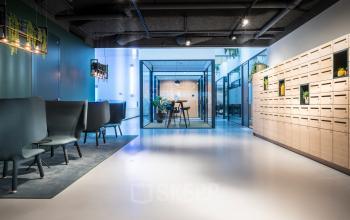 Modern kantoorpand aan de Bargelaan 200, Leiden, met comfortabele zitjes, moderne lockers en een vergaderruimte in glazen cabine.