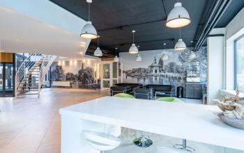 Ruime kantoorpand op Schipholweg 55-89 in Leiden r met modern interieur, ingericht met zitjes en schilderingen op de muur.
