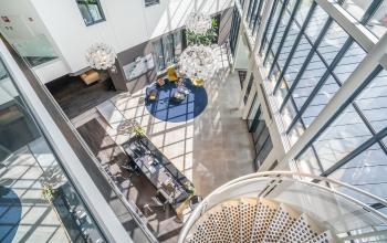 Moderne kantoorruimte in het kantoorpand op Kanaalpark 140, Leiden, met ruime werkplekken, grote ramen en enkele mensen die zakelijke gesprekken voeren. Ideaal om een kantoor te huren.