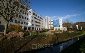 Exterieur van het kantoorpand op Kanaalpark 140 in Leiden, met groen rondom het gebouw. Kantoorruimte huren mogelijk.