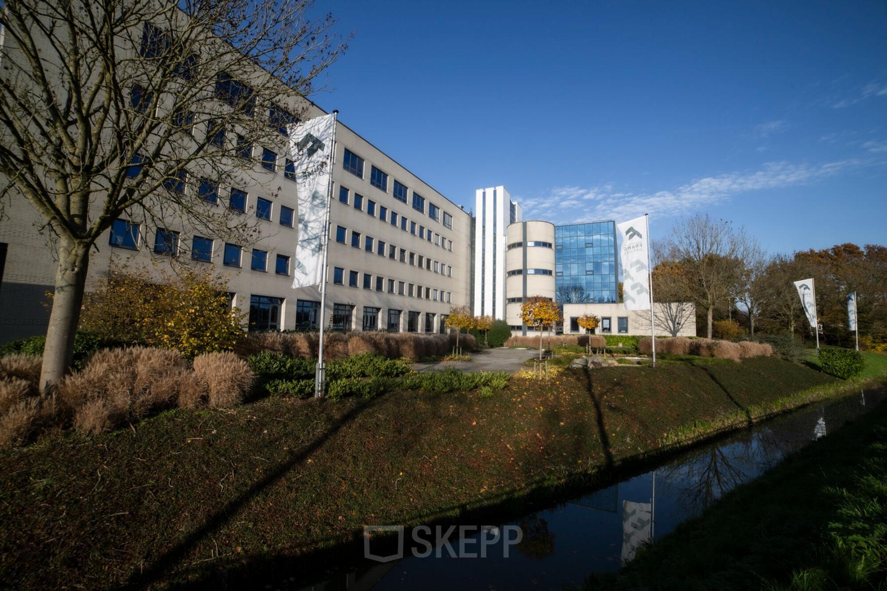 Exterieur van het kantoorpand op Kanaalpark 140 in Leiden, met groen rondom het gebouw. Kantoorruimte huren mogelijk.