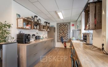 Modern ingerichte kantoorpantry in kantoorpand aan Kanaalpark 157 in Leiden, met koffiemachine en zitgedeelte voor een pauzemoment.