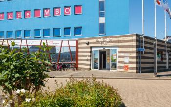 Exterieur van kantoorpand Het Ravelijn 1-11, Lelystad, geschikt voor kantoorruimte huren, met opvallende rood-blauwe gevel.