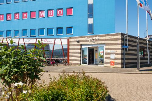 Exterieur van kantoorpand Het Ravelijn 1-11, Lelystad, geschikt voor kantoorruimte huren, met opvallende rood-blauwe gevel.