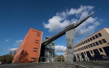 Exterieur van kantoorpand op Fokkerstraat 16 in Leusden, omgeven door helderblauwe lucht en moderne bouwstijl, geschikt voor kantoorruimte huren.