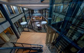 Ruime, moderne kantoorruimte huren in Leusden, gelegen aan de Fokkerstraat 16, met glazen balustrades en open vloeren. Ideaal voor innovatief werken en netwerken.