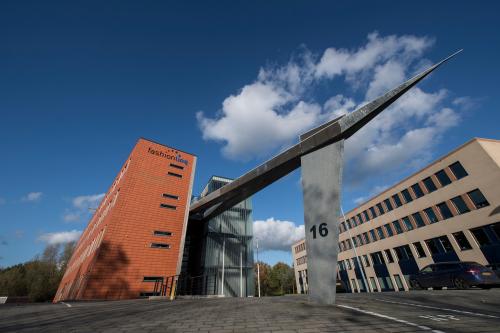 Exterieur van kantoorpand op Fokkerstraat 16 in Leusden, omgeven door helderblauwe lucht en moderne bouwstijl, geschikt voor kantoorruimte huren.