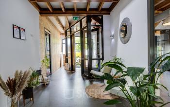 In het kantoorpand op Hamersveldseweg 120, Leusden, is een uitnodigende entree te zien met veel groen en een houten plafond. Overweeg om deze kantoorruimte te huren voor jouw bedrijf.