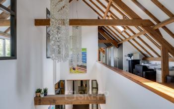 Kantoorruimte huren op Hamersveldseweg 120 in Leusden met een open vloerplan en moderne afwerking. Zicht op opmerkelijke houten balken en grote ramen voor natuurlijk lichtinval in het kantoorpand.