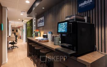 Koffiehoek in kantoorpand aan de Horsterweg 24, Maastricht-Airport, met een moderne koffiemachine en zitplaatsen. Ideale plek voor een ontspannen pauze tijdens het kantoorwerk.